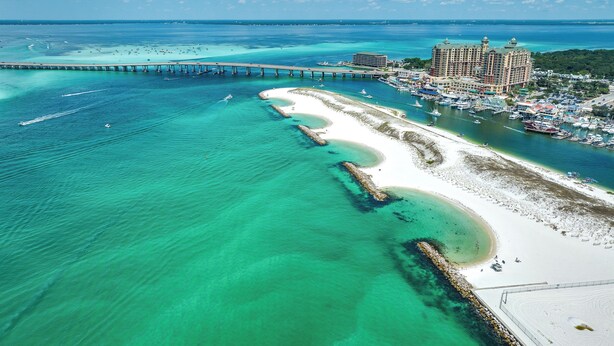An aerial view of a coastal resort with a long pier, a large hotel, and a sandy beach. - Great Location- Heart of Miramar Beach! So Close to Pool, Beach, & More! (Miramar Beach)