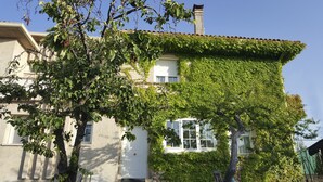 Una casa con facciata bianca, un camino e una finestra.