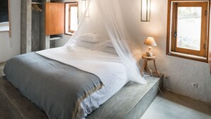 A bedroom with a bed, a bedside table with a lamp, a window, and a wardrobe. - Monte Gois Country House e Spa (Almodôvar)