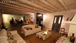 A cozy interior with a wooden ceiling, a dining area, and a living room with a white sofa and a coffee table. - Monte Gois Country House e Spa (Almodôvar)