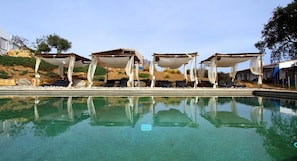 A swimming pool with four covered seating areas, clear water, and a hillside backdrop. - Monte Gois Country House e Spa (Almodôvar)
