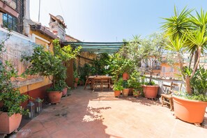 Relax in this serene courtyard, surrounded by lush greenery and a beautiful mural.