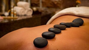 A massage table with black stones placed on a person's back. - Flair Hotel zur Therme (Erwitte)