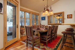 Enjoy meals in this dining area with a traditional table set for four, intricately patterned chairs, and a large mirror above.