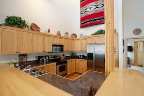 Enjoy cooking in this fully equipped kitchen with a refrigerator, oven, microwave, and sink.