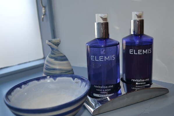 Duas embalagens de shampoo Revitalise Me da Elemis sobre uma bancada de banheiro.