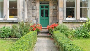A traditional stone building with a green door labeled "Derwent House."