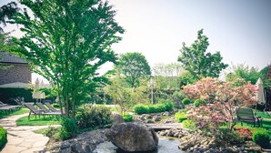 A garden with a pond, rocks, and a pathway. - Ringhotel Teutoburger Wald (Tecklenburg)