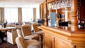 A bar area with a wooden counter and multiple chairs. - Ringhotel Teutoburger Wald (Tecklenburg)