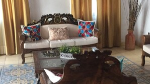 A living room with a wooden coffee table, a sofa with colorful cushions, and a patterned floor. - Casa Boutique San Miguel Serenata (San Miguel de Allende)