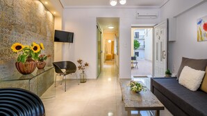 Un salon moderne avec un canapé, une table basse et un téléviseur fixé au mur.