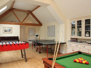 Une pièce équipée d’un baby-foot, d’une table de billard et d’un jeu de fléchettes.