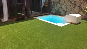 A swimming pool with a stone wall and a covered patio area. - CORRALEJO-Villa Tranquila with private pool (La Oliva)