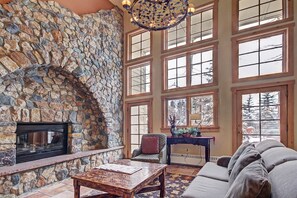 A stone fireplace, large windows, and a cozy seating area.