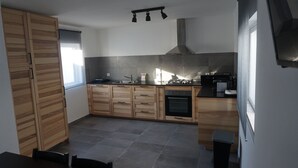 Una cocina moderna con armarios de madera, una estufa a gas y un horno empotrado.