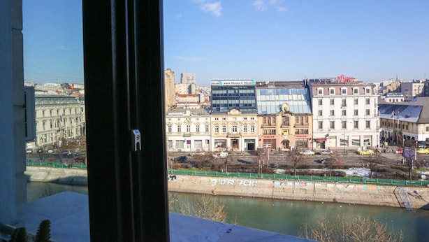 A cityscape with various buildings, including a modern glass building and older, traditional architecture. - Diana’s flat No 2  Bucharest - Old  City (Bucharest)