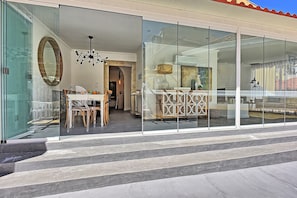 A modern interior with a dining area, a decorative fireplace, and a glass storefront. - Portas do Sol Terrace –pure charm in Alfama (A/C) (Lisbon)