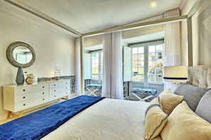 A bedroom with a bed, a dresser, a mirror, a window, and a balcony. - Portas do Sol Terrace –pure charm in Alfama (A/C) (Lisbon)