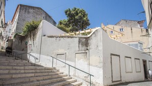 A set of stone steps leading up to a white building with a small door and a window. - Portas do Sol Terrace –pure charm in Alfama (A/C) (Lisbon)