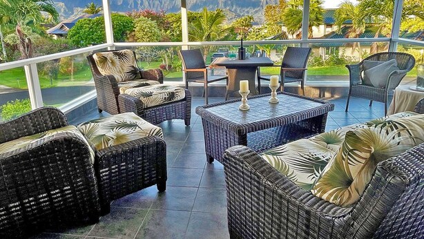 A covered outdoor seating area with wicker furniture and a view of mountains and greenery. - Ramatici Ohana Hale, Fabulous updated home with shared pool and tennis court. (Princeville)