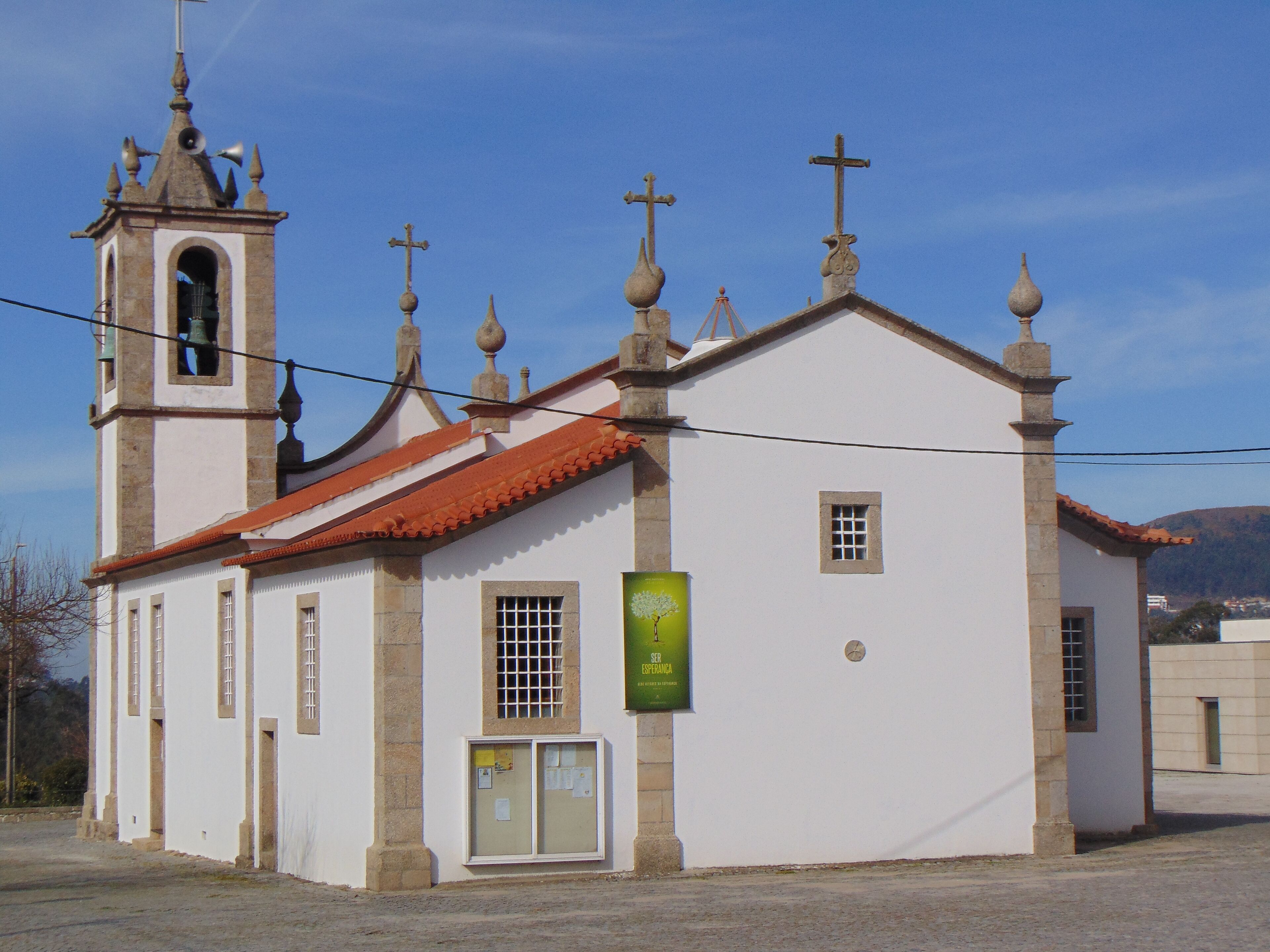 A white church with a bell tower and crosses on the roof.