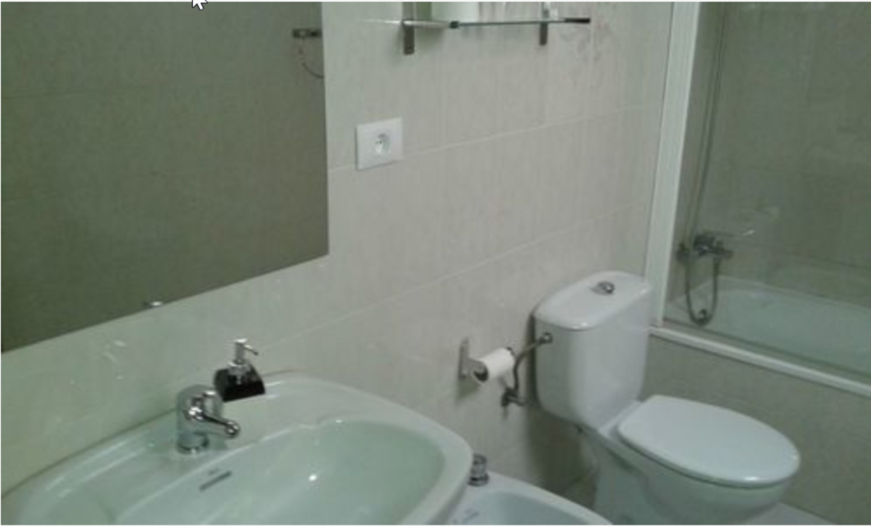 Een bad/douchecombinatie, een bidet, handdoeken
