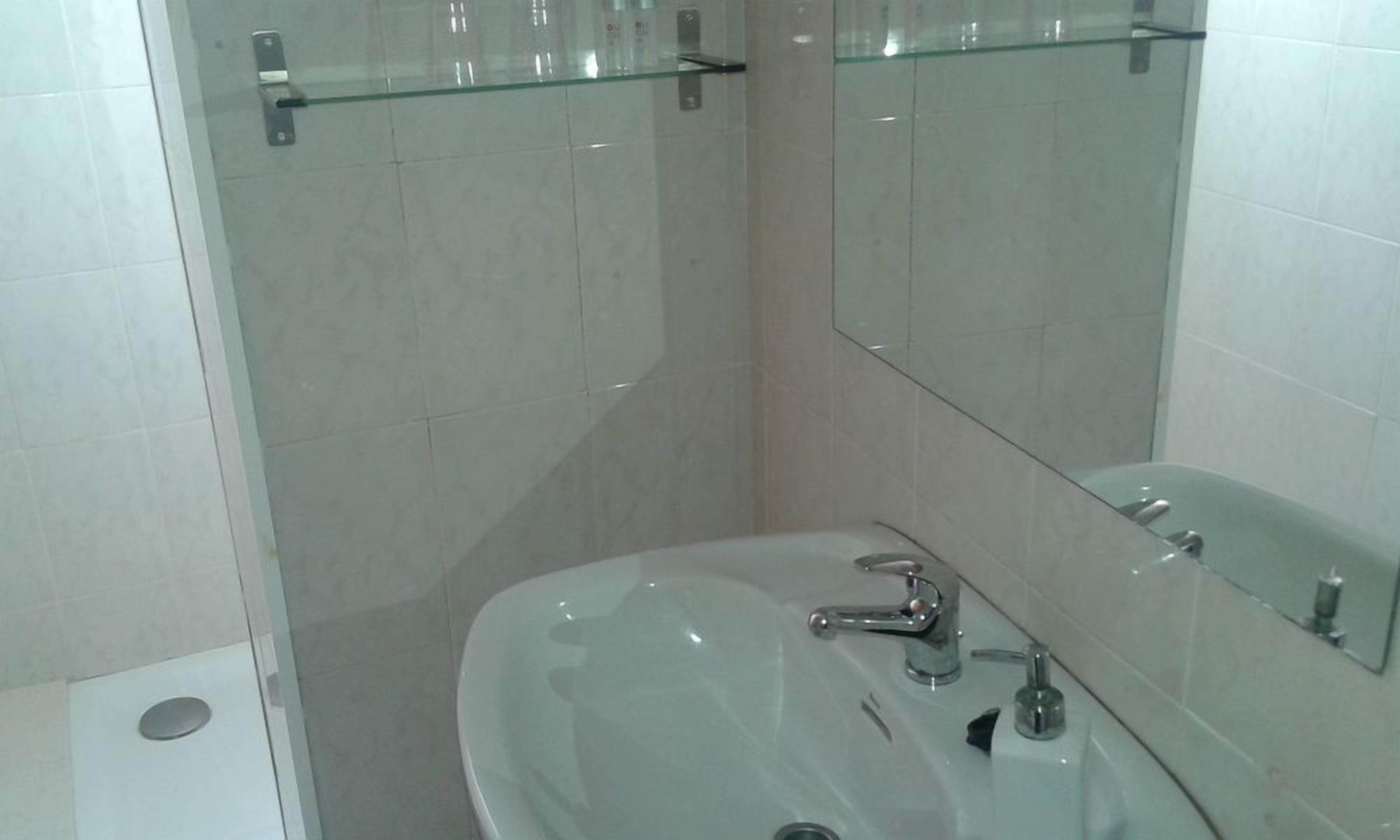 Een bad/douchecombinatie, een bidet, handdoeken