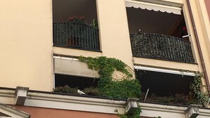 A multi-story building with balconies, some with metal railings and others with decorative elements.