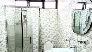 A bathroom with a glass shower enclosure, a toilet, and a sink with a mirror. - Silver Hotel (Kigali)