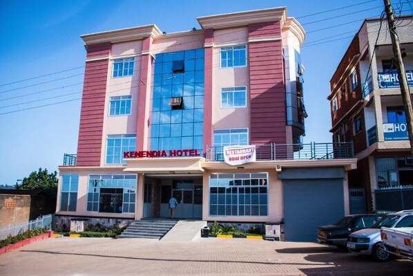 A hotel with a prominent sign reading "KENNEDIA HOTEL" and a "RESTAURANT NOW OPEN" sign.