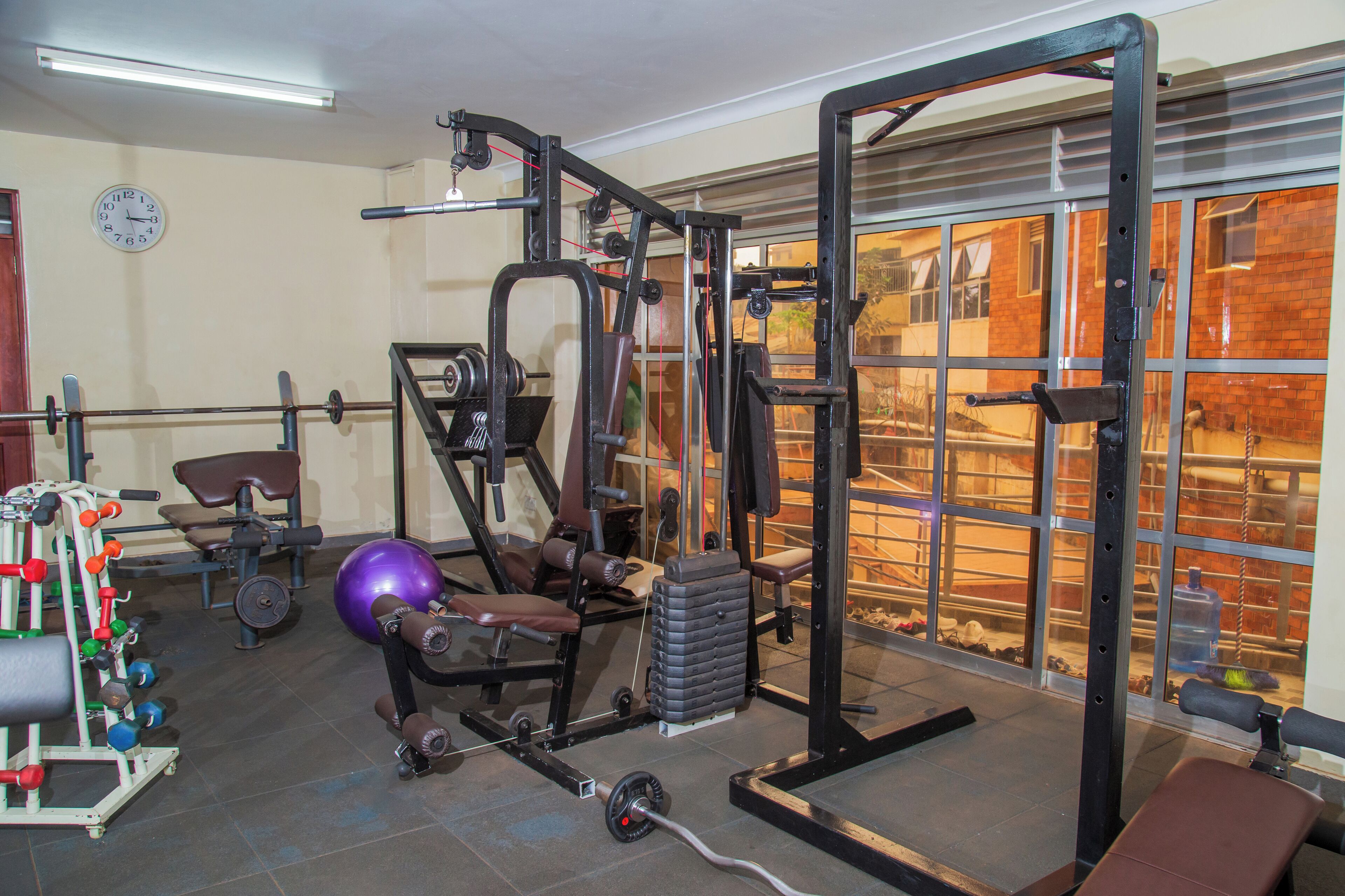 Ein Fitnessraum mit Gewichthebern, einer Bank und einem großen Fenster.