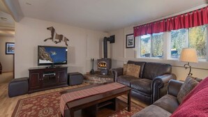 A living room with a fireplace, leather sofa, television, and a rug. - JHRL - Tensleep A2 - First floor condominium located in Teton Village (Teton Village)
