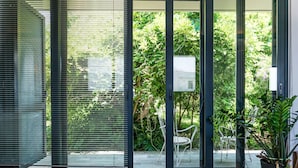 A modern interior with a sliding glass door leading to a garden. - Artistic Private Pool Villa with Gorgeous Gardens (Chania)