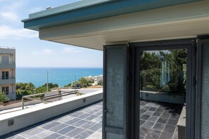 Un balcon avec vue sur la mer et les bâtiments.