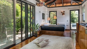 A modern bedroom with a large bed, a wooden ceiling, and a view of the outdoors. - Artistic Private Pool Villa with Gorgeous Gardens (Chania)