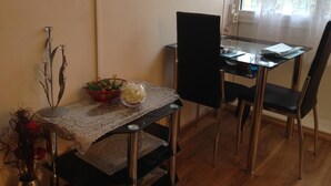 Uma área de jantar com uma mesa, cadeiras e um vaso de flores.