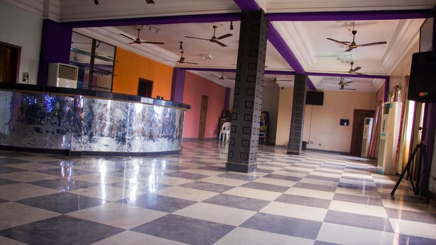 A hotel lobby with a checkered floor, ceiling fans, and a reception desk. - Emota Paradise Phase 2 (Lagos)