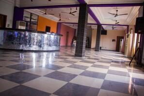 A hotel lobby with a checkered floor, ceiling fans, and a reception desk. - Emota Paradise Phase 2 (Lagos)