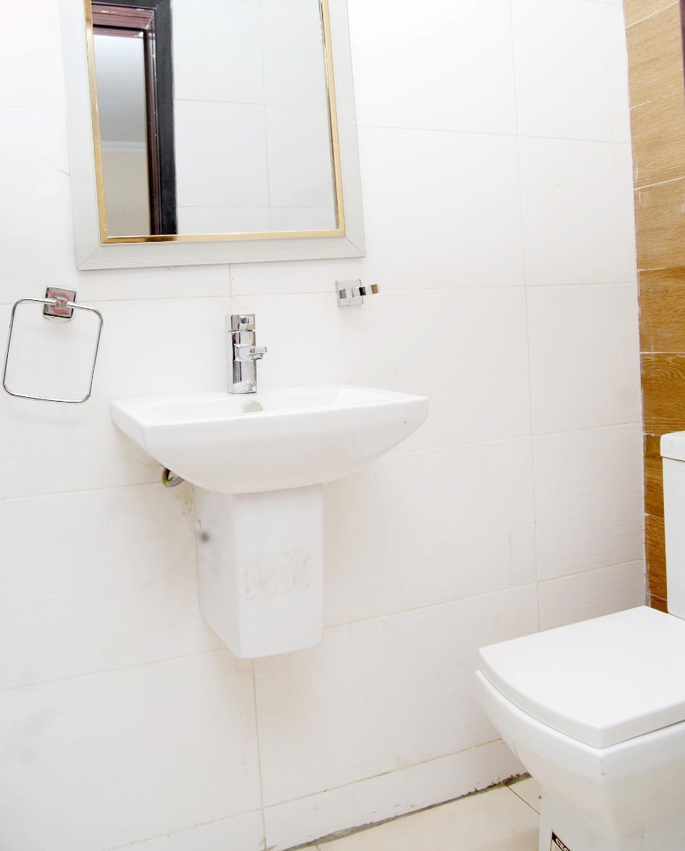 A bathroom with a white sink, a mirror, and a toilet.