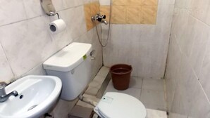 A small bathroom with a toilet, sink, and shower. - SureRest Hotel & Suites (Lagos)