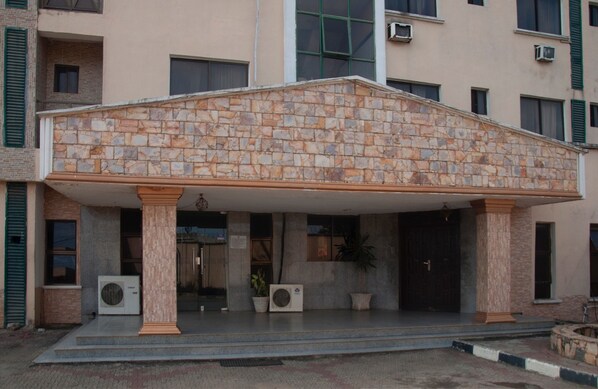 A building with a stone facade, columns, and a covered entrance.