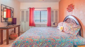 A bedroom with a bed, a ceiling fan, a window with shutters, and a mirror. - C 401 Spacious Well Furnished Ocean View Condo (Puerto Peñasco)