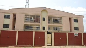 A two-story building with barred windows and a sign indicating it is a hotel. - Bella Rose Hotel (Lagos)