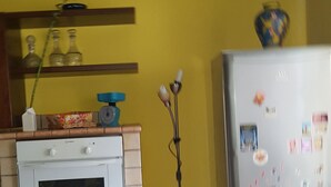 Een keuken met een witte oven, een koelkast en een gele wand.
