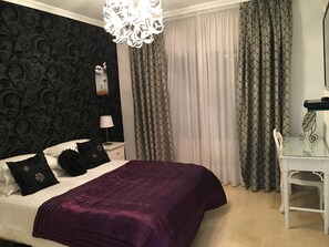 Une chambre à coucher avec un lit, une table de chevet, une lampe, une chaise et un bureau.
