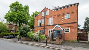 A two-story brick building with a front door, windows, and a satellite dish. - Stylish boutique apartment in trendy West Didsbury (Manchester)