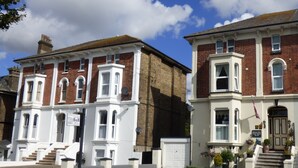 A row of traditional brick houses with white trim and bay windows. - Maison Dieu Guest House (Dover)