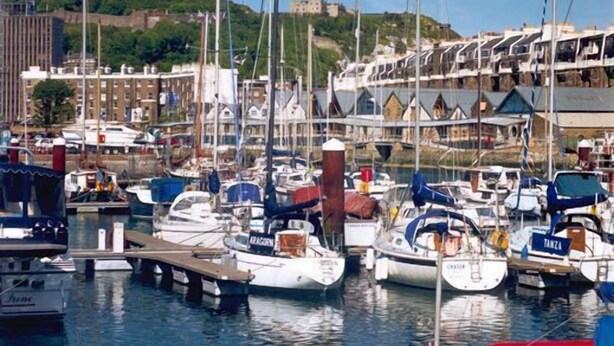 A marina with various boats docked, a castle in the background, and buildings with traditional architecture. - Maison Dieu Guest House (Dover)