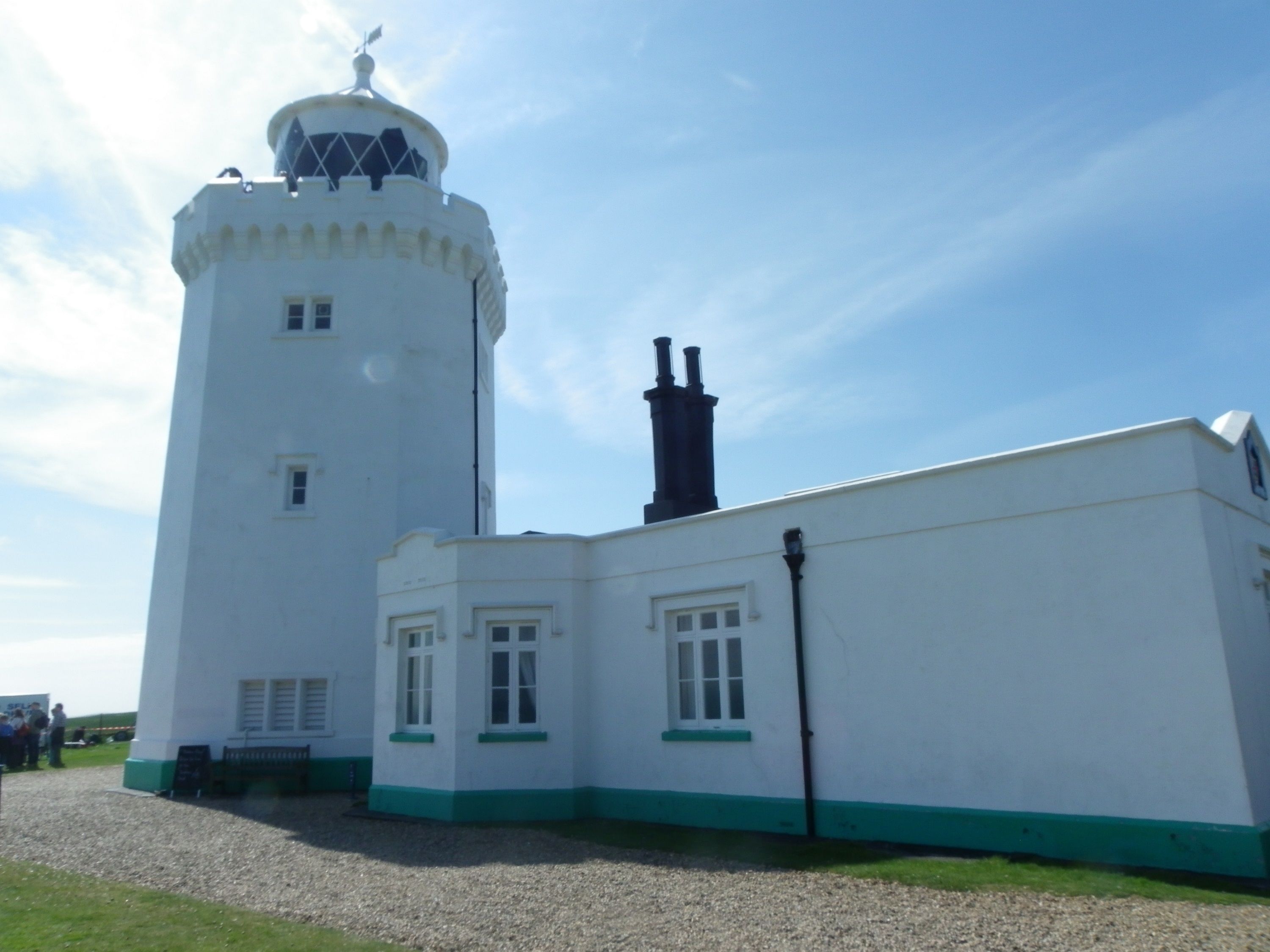 A white building with a tower and a flat-roofed section.