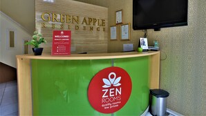 A reception desk at Green Apple Residence with a sign indicating it's a Zen Rooms property, offering quality rooms at low prices. - ZEN Rooms Kampung Bali Tanah Abang (Jakarta)